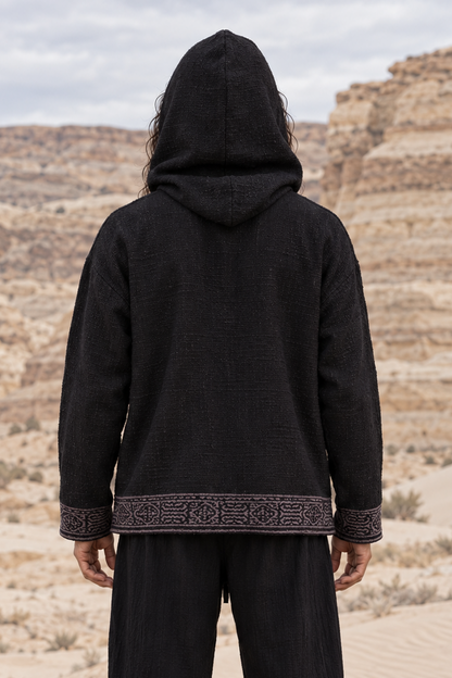 Back view of black cotton hoodie with the hood up, grey block-printed band along the hem and cuffs